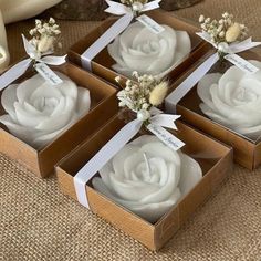 four small boxes with white flowers in them