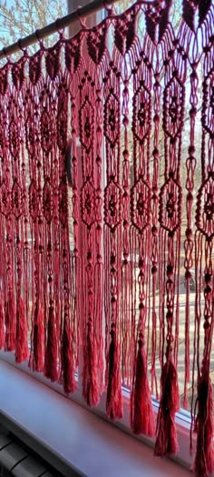 red tassels hanging on the side of a window