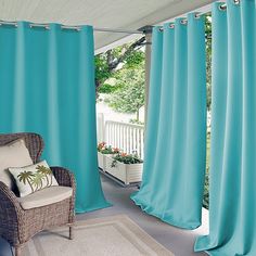 a chair sitting on top of a rug next to a window covered in blue curtains