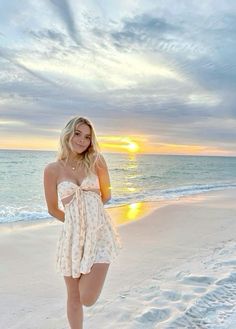 a woman standing on top of a sandy beach