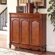 a large wooden cabinet sitting on top of a hard wood floor next to a stair case