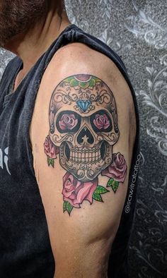 a man with a skull and roses tattoo on his arm