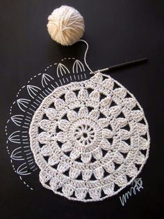 a crocheted doily with a ball of yarn next to it