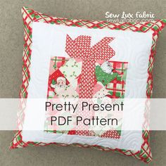 the pretty present pillow is made with red, green and white quilting on it