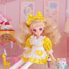 a doll with blonde hair is sitting on a table next to other dolls and toys