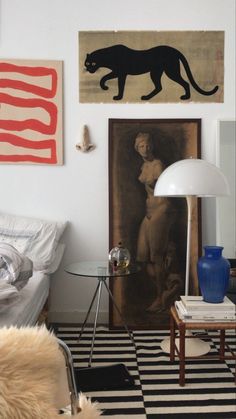 a living room filled with furniture and paintings on the wall