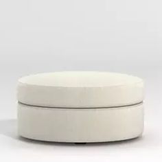 a white round ottoman sitting on top of a floor