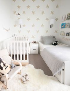 a white baby's room with stars on the wall and a crib next to it