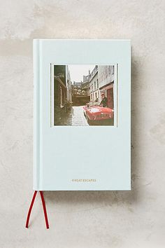 a white book with a red handle hanging from it's side on a wall