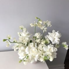 a white vase filled with flowers on top of a table