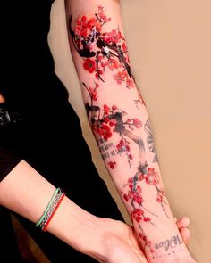 a woman's arm covered in tattoos with flowers on it