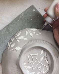 someone is decorating a plate with white paint