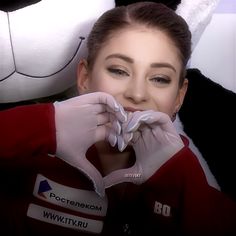 a woman in white gloves is posing next to a stuffed animal