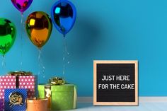 colorful balloons and presents are next to a sign that says just here for the cake