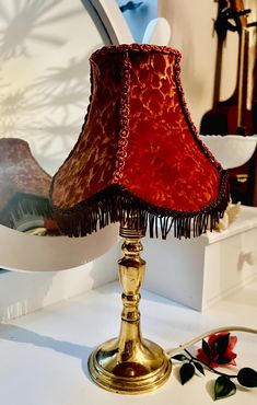 a red lamp sitting on top of a table next to a mirror