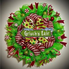 a green wreath with candy canes and bows on it that says grin's hair