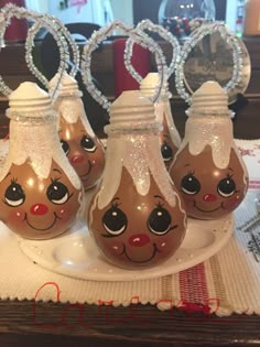 three glass vases with faces on them sitting on a tablecloth covered place mat