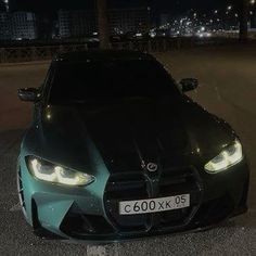 a black and blue sports car parked on the side of the road at night time