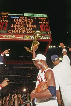 the basketball player is holding up his trophy in front of an audience at a game