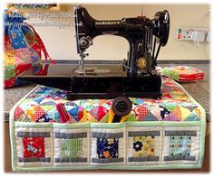 a sewing machine sitting on top of a table next to a quilted case and pillow