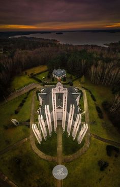 an aerial view of a large white building in the middle of a green field at night