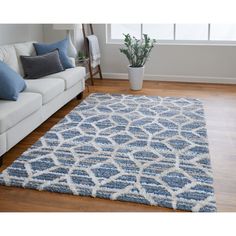 a blue and white rug in the middle of a living room with a couch next to it