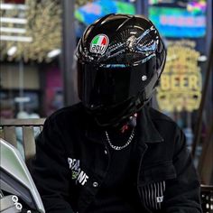 a person wearing a motorcycle helmet sitting on a bench