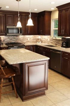 a kitchen with brown cabinets and marble counter tops