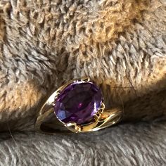 a purple ring sitting on top of a furry surface