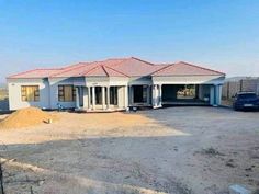 a large house sitting in the middle of a dirt lot