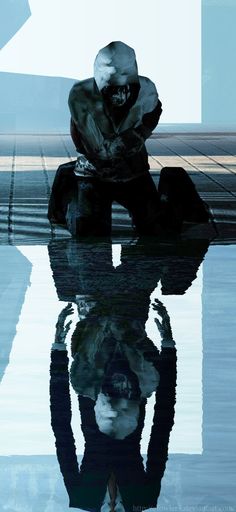 a person sitting on the ground with their reflection in the water