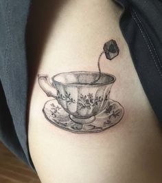 a black and white photo of a teacup tattoo