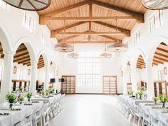 the inside of a building with tables and chairs set up for a formal dinner or function