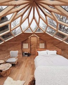 a bed sitting under a wooden roof next to a white chair and footstool