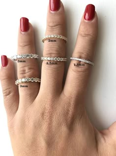 a woman's hand with five different sized rings on her fingers, and the width of each ring