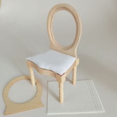 a wooden chair with a white cushion on it and a small piece of wood next to it