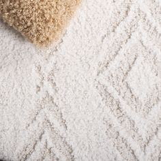 a close up view of a carpet with white and brown colors on the top part of it