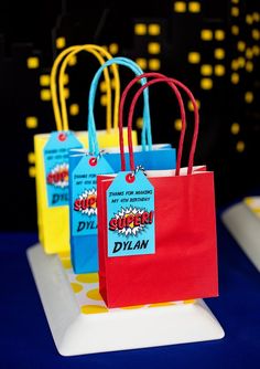 three bags with tags on them are sitting on a white plate in front of a blue and yellow backdrop