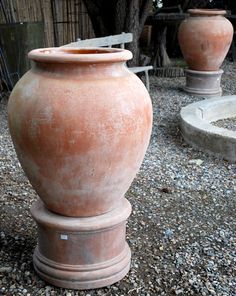 two large vases sitting on top of gravel