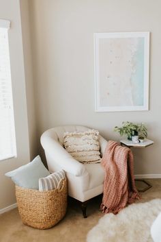 a living room with a white chair and a basket on the floor next to it