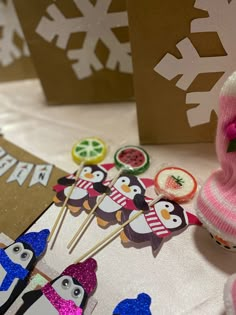 there is a small cupcake decorated with penguins and snowflakes on the table