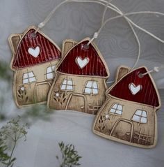 three ceramic houses with hearts hanging from strings