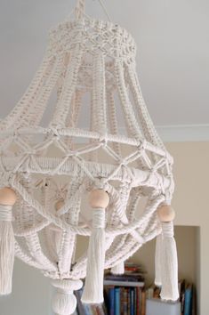 a white chandelier with tassels hanging from it