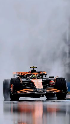 a red and black race car driving on a wet track