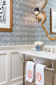 a white sink sitting under a bathroom mirror next to a wall mounted faucet