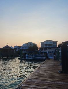 a dock with boats and houses in the background