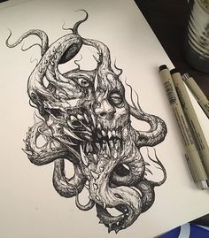 a drawing of an octopus attacking a human head on paper with markers next to it