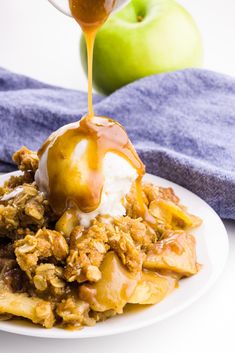 an apple pie with ice cream and caramel syrup being drizzled over it