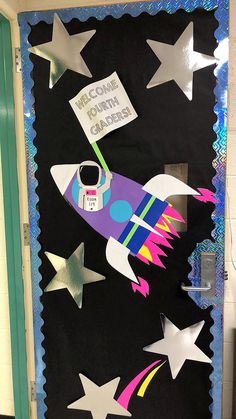 a door decorated with paper stars and a rocket ship