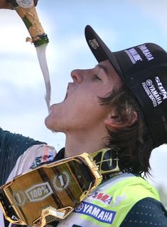 a man holding up a trophy in his right hand and wearing goggles on his left